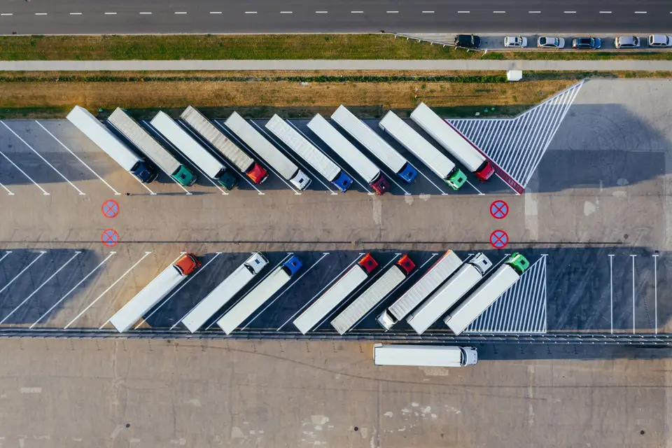 Aerial view of semi-trucks parked in angled rows at a truck lot